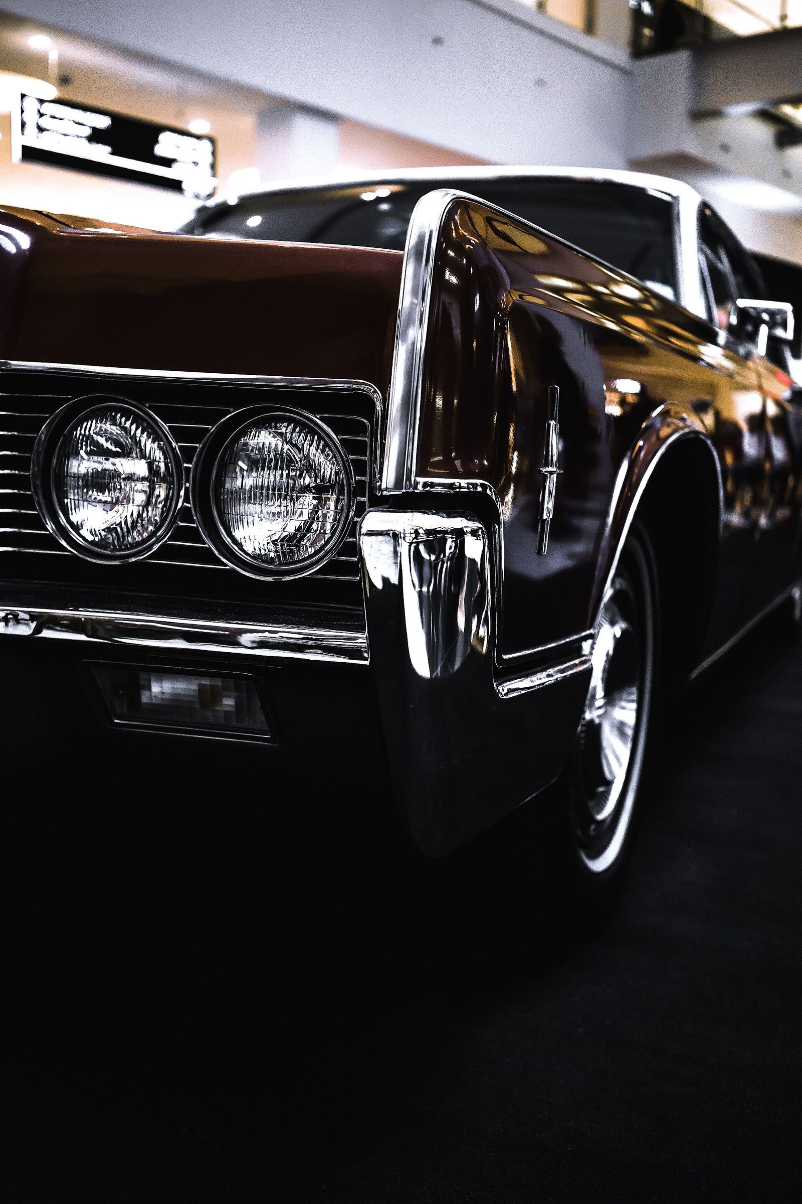 Front of a polished vintage car in a dark studio